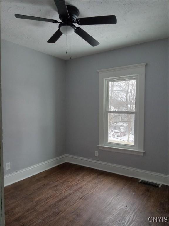 empty room featuring ceiling fan and dark wood-type flooring