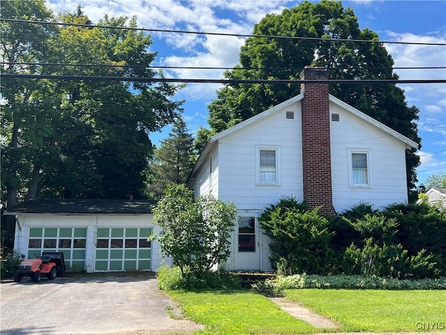 view of front of house with a front lawn, an outdoor structure, and a garage