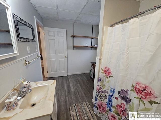 bathroom with a paneled ceiling, vanity, and hardwood / wood-style flooring