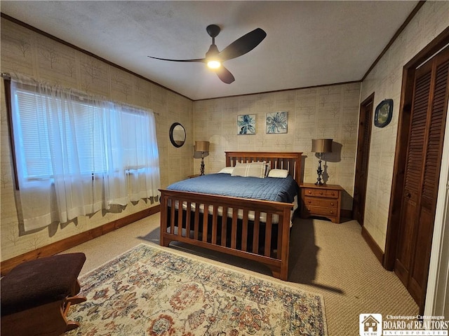 bedroom featuring ceiling fan, light colored carpet, crown molding, and a closet