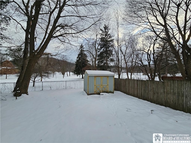 yard covered in snow featuring a storage unit