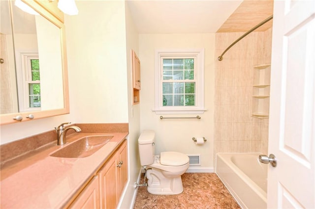 full bathroom with toilet, vanity, and tiled shower / bath combo