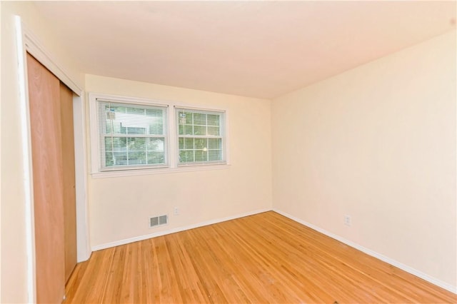 unfurnished bedroom with hardwood / wood-style flooring and a closet