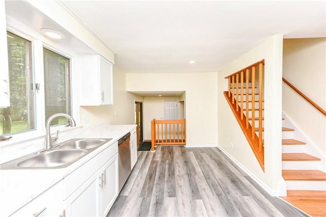 kitchen with white cabinetry, dishwasher, sink, and light hardwood / wood-style floors