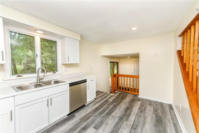 kitchen featuring white cabinets, dishwasher, sink, and hardwood / wood-style floors