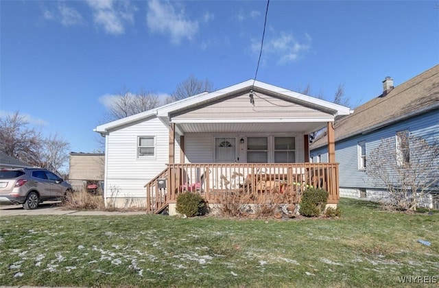 bungalow-style house featuring a front lawn and covered porch