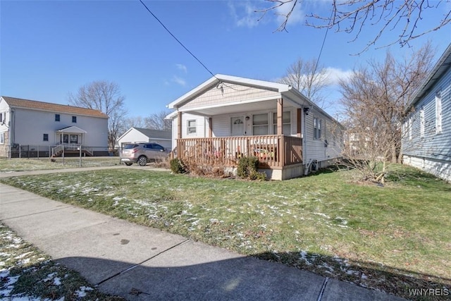 bungalow featuring covered porch and a front lawn