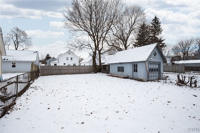 yard layered in snow with a garage and an outdoor structure