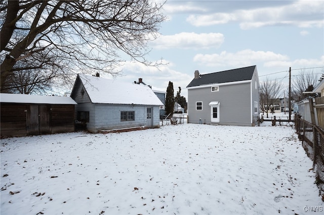 view of snow covered back of property