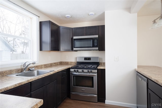 kitchen with dark hardwood / wood-style flooring, stainless steel appliances, and sink