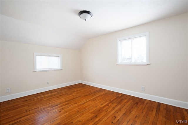 additional living space featuring plenty of natural light, wood-type flooring, and vaulted ceiling