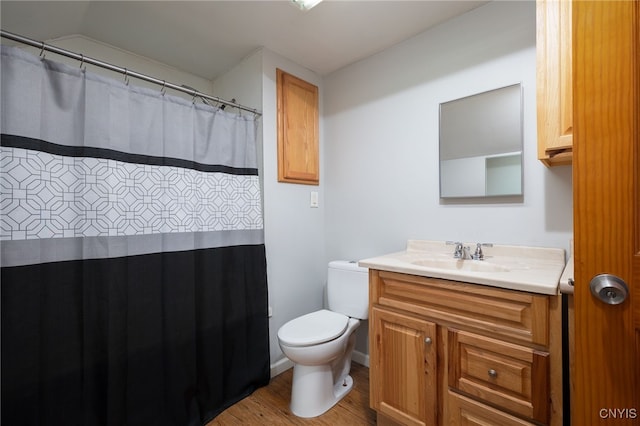 bathroom with vanity, hardwood / wood-style flooring, toilet, and vaulted ceiling