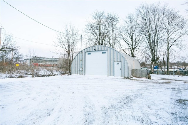 snow covered structure with a garage