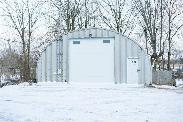 snow covered structure featuring a garage