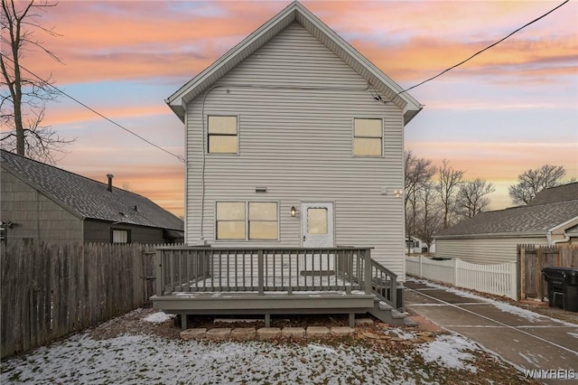 snow covered house featuring a wooden deck