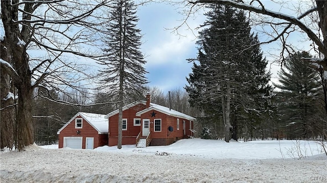 view of snowy exterior with a garage