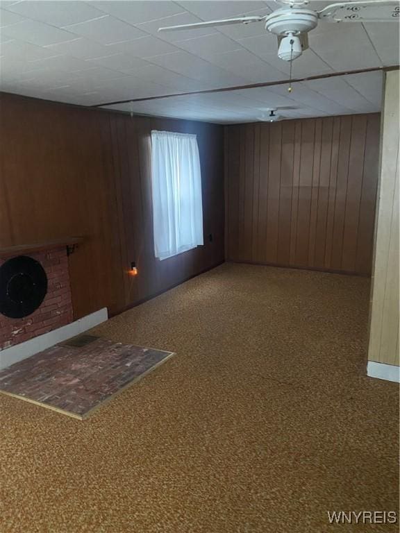 spare room featuring carpet and wood walls