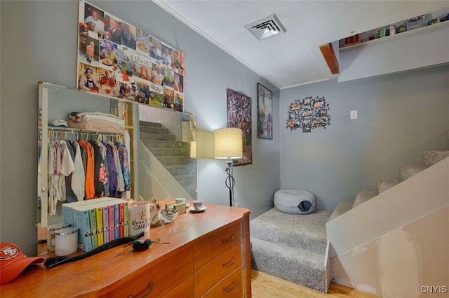 bedroom featuring crown molding, light hardwood / wood-style floors, and a closet