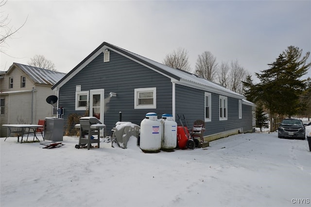 view of snow covered back of property