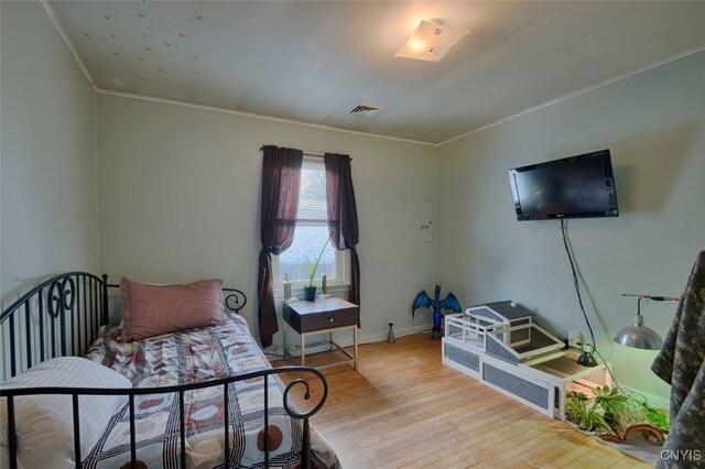 bedroom featuring light hardwood / wood-style floors and ornamental molding