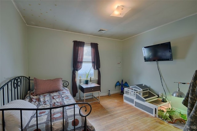 bedroom with crown molding and light hardwood / wood-style flooring
