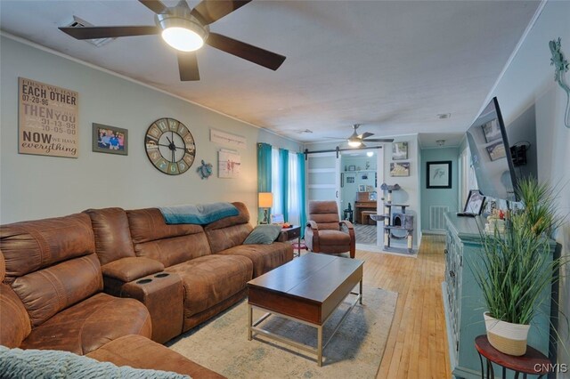 43804 Second St, Alexandria, NY 13679 - living room with ceiling fan, crown molding, light wood-style flooring, and a barn door