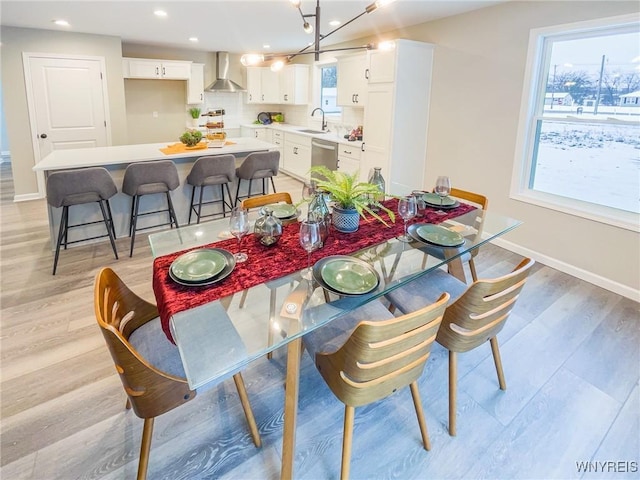 dining space featuring a chandelier, sink, and light hardwood / wood-style floors