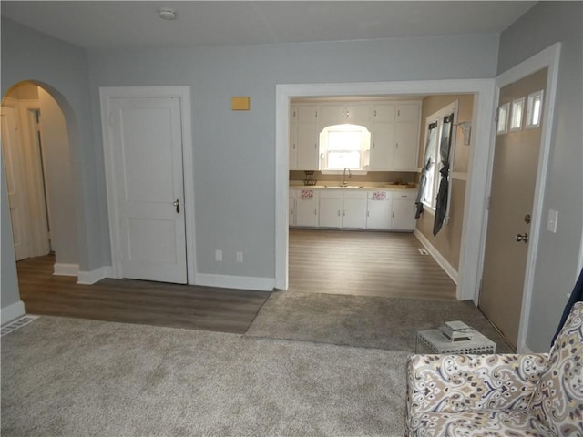 unfurnished living room featuring sink and dark colored carpet