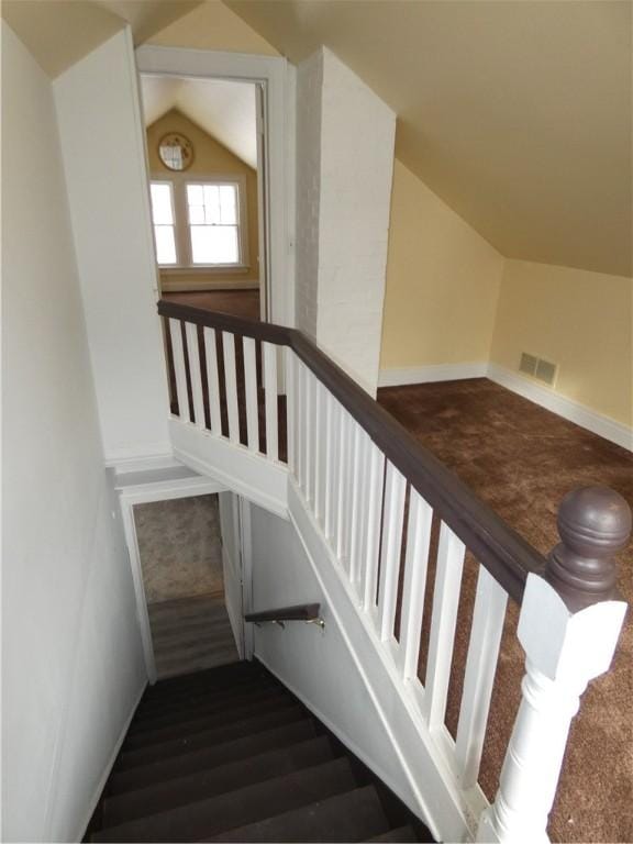 stairway with wood-type flooring and lofted ceiling