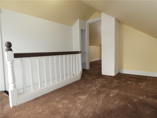 additional living space with dark colored carpet and lofted ceiling