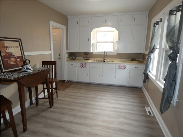 kitchen featuring sink, white cabinets, and light hardwood / wood-style flooring