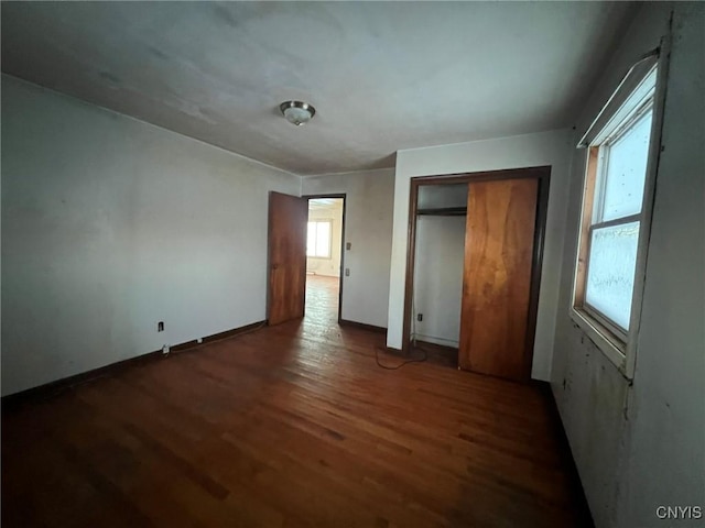 unfurnished bedroom with a closet and dark hardwood / wood-style flooring