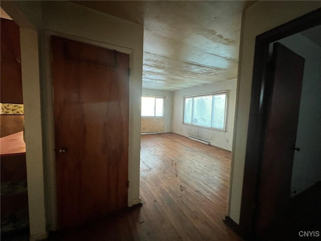 hall with wood-type flooring and a baseboard radiator