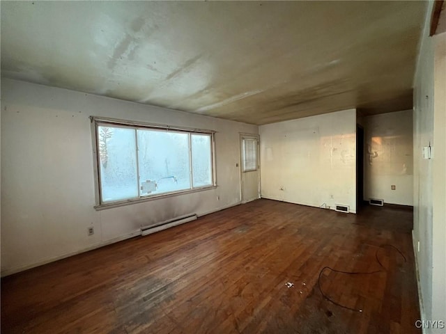 spare room featuring dark hardwood / wood-style flooring and baseboard heating