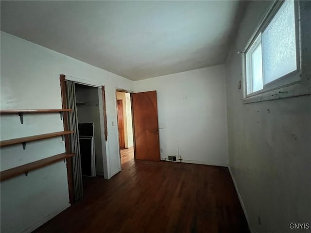 unfurnished bedroom with dark hardwood / wood-style floors