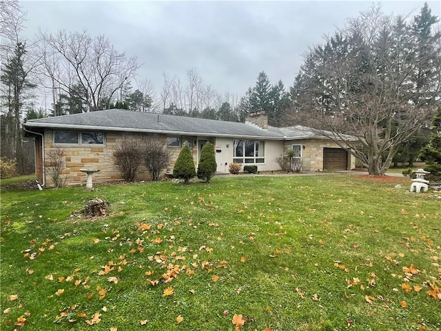 ranch-style house featuring a garage and a front lawn