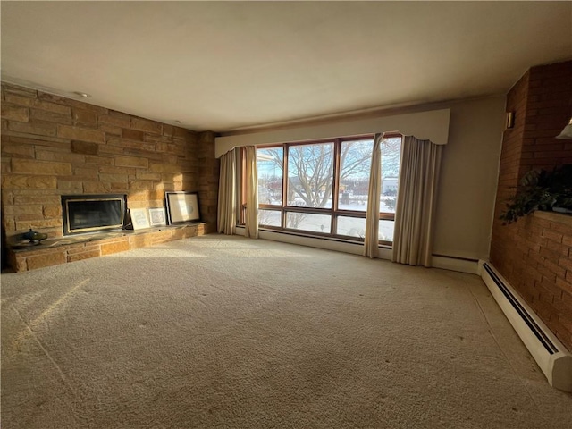 unfurnished living room with carpet flooring, a stone fireplace, and a baseboard radiator