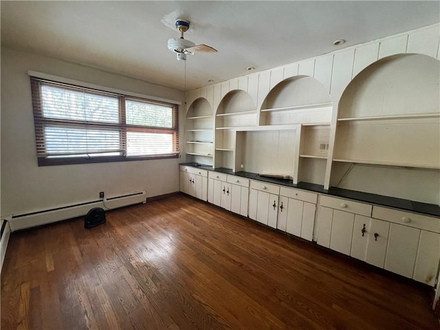 unfurnished living room featuring built in shelves, ceiling fan, dark wood-type flooring, and a baseboard radiator