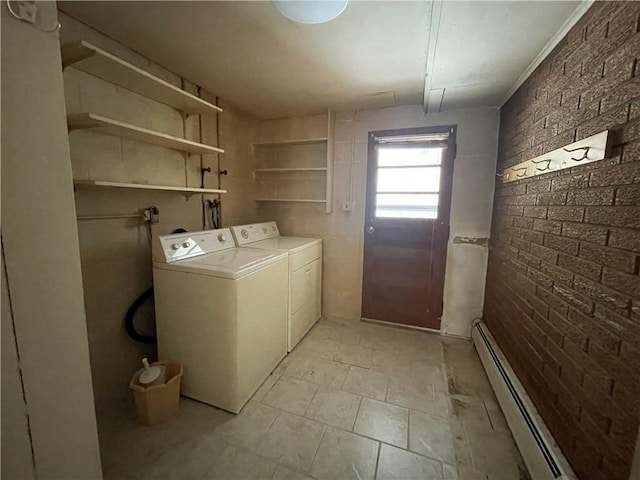 laundry area featuring washer and clothes dryer, brick wall, and a baseboard heating unit