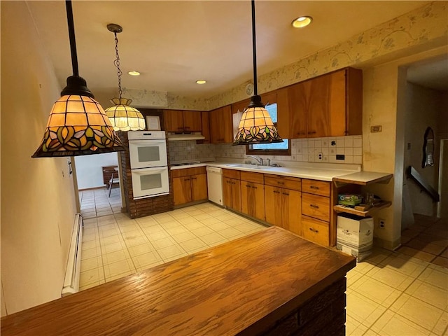 kitchen with sink, baseboard heating, backsplash, white appliances, and decorative light fixtures