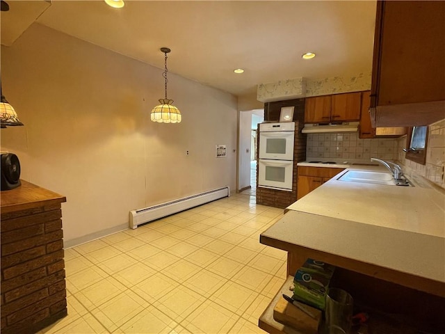 kitchen with white appliances, backsplash, a baseboard heating unit, sink, and hanging light fixtures