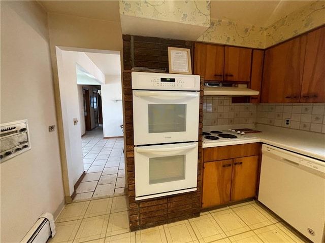 kitchen featuring white appliances, baseboard heating, and backsplash