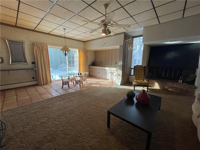 living room featuring tile patterned floors, a paneled ceiling, ceiling fan with notable chandelier, and a baseboard heating unit