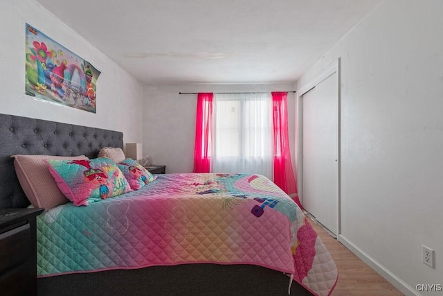 bedroom with light wood-type flooring and a closet