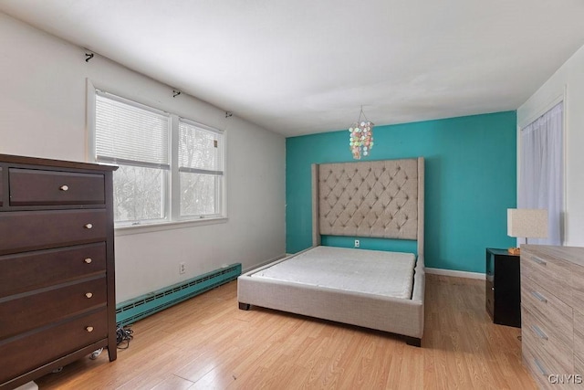 bedroom with light wood-type flooring and baseboard heating