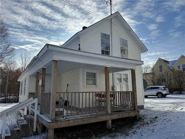 view of snowy exterior featuring a porch