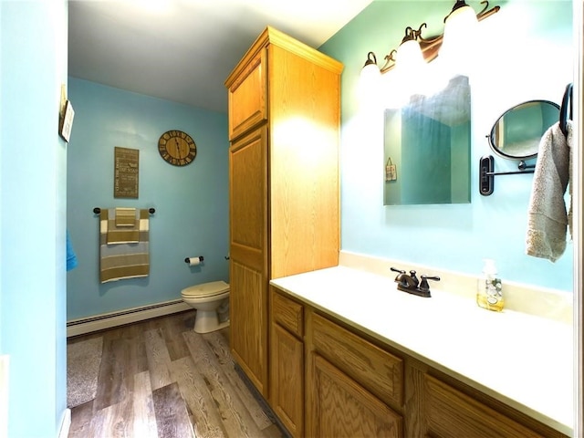 bathroom with wood-type flooring, a baseboard heating unit, vanity, and toilet