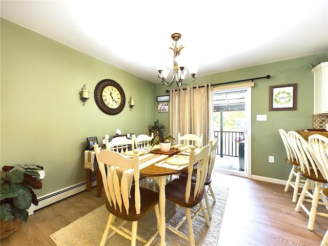 dining area featuring baseboard heating, hardwood / wood-style floors, and a notable chandelier