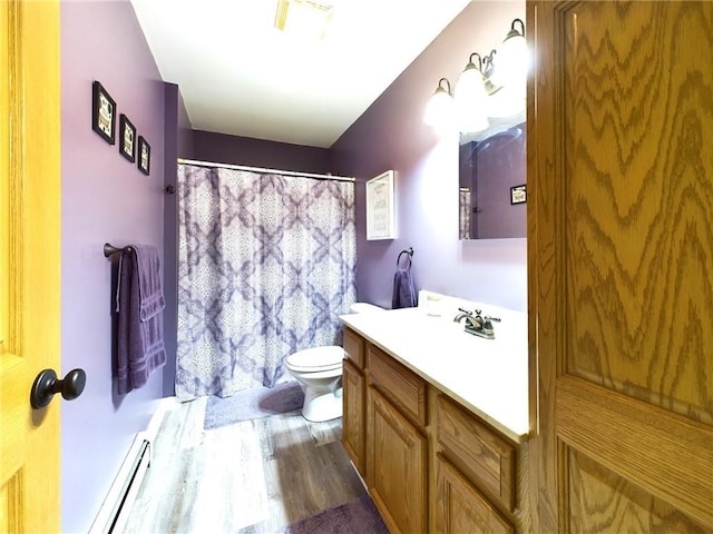 bathroom with toilet, a baseboard heating unit, hardwood / wood-style flooring, and vanity