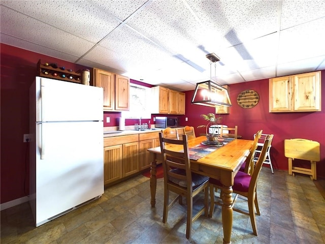 dining space featuring a drop ceiling and sink